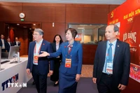 El miembro del Comité Central del Partido y ministro de Justicia, Nguyen Hai Ninh (izq.), visita el área de trabajo de la Agencia Vietnamita de Noticias en el centro de prensa del XIV Congreso Nacional del Partido. (Fuente: VNA)