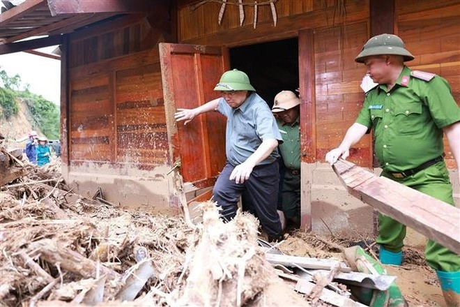 El primer ministro Pham Minh Chinh inspecciona y dirige las labores de recuperación tras las inundaciones, riadas y deslizamientos de tierra en la comuna de Xa Dung. (Foto: VNA) pmc.jpg