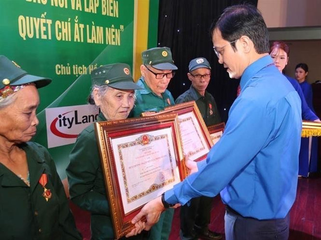 Bui Quang Huy, miembro suplente del Comité Central del Partido, vicepresidente del Comité Central del Frente de la Patria de Vietnam y primer secretario del Comité Central de la Unión de Jóvenes Comunistas Ho Chi Minh, entregó la "Medalla al Mérito de los Jóvenes Voluntarios Gloriosos" a un exvoluntario juvenil. (Foto: VNA) vna-potal-ky-niem-75-nam-ngay-truyen-thong-luc-luong-tnxp-viet-nam-8149437-1.jpg