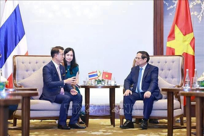 El primer ministro Pham Minh Chinh (der.) recibe al vicepresidente del Kasikornbank (KBank) de Tailandia. (Foto: VNA) minh-chinh1.jpg
