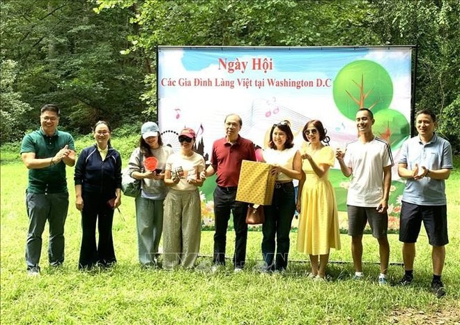 El embajador Nguyen Quoc Dung (centro) entrega obsequios a los ganadores de los juegos deportivos del festival. (Foto: VNA) ngay-gia-dinh-04082025-01.jpg