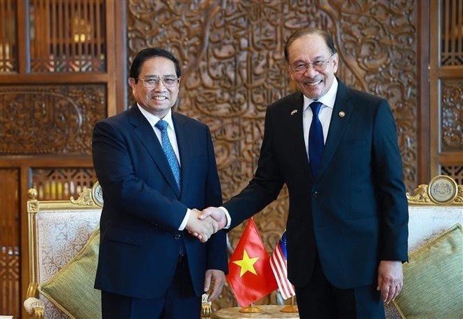 El primer ministro vietnamita, Pham Minh Chinh (izq.), estrecha la mano de su homólogo malasio, Anwar Ibrahim, durante su reunión en Kuala Lumpur el 25 de mayo. (Foto: VNA) vna-potal-thu-tuong-pham-minh-chinh-hoi-dam-voi-thu-tuong-malaysia-anwar-ibrahim-8053222.jpg