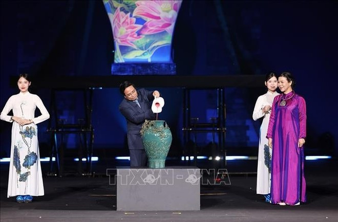 El primer ministro Pham Minh Chinh participa en una pintura ceremonial de cerámica tradicional de cinco colores (Foto: VNA) e.jpg