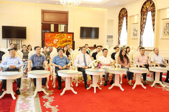 Los delegados ven un programa especial de televisión en vivo de la Televisión Nacional de Vietnam. (Fuente: VNA) vna-potal-dai-su-quan-viet-nam-tai-bac-kinh-to-chuc-theo-doi-le-cong-bo-cac-nghi-quyet-ve-sap-nhap-don-vi-hanh-chinh-8123069.jpg