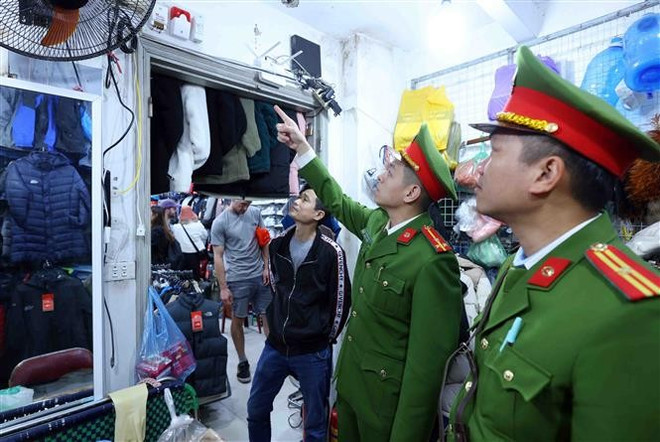 La Policía del distrito de Hang Bac inspecciona las labores de prevención de incendios y rescate en un negocio de la calle Hang Dau. (Foto: VNA) vna-potal-cong-an-ha-noi-san-sang-phong-chong-giac-lua-dem-lai-binh-yen-cho-nguoi-dan-7829404.jpg