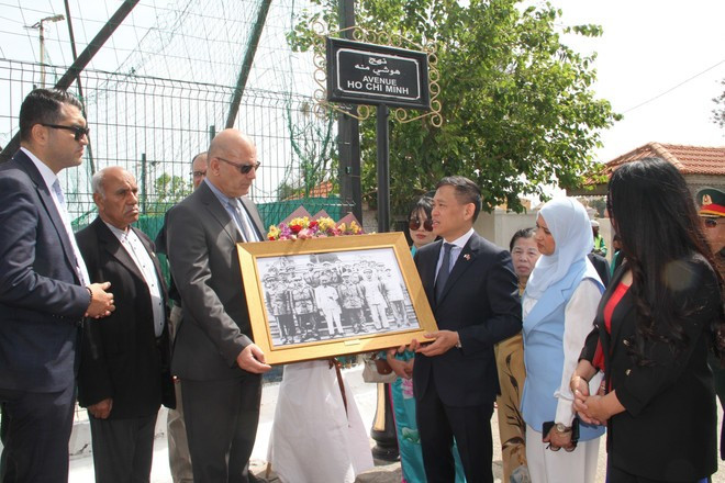 El embajador Tran Quoc Khanh presenta a Djamel Belamou, presidente del Rais Hamidou, un suburbio de Argel donde se encuentra la avenida Ho Chi Minh, una fotografía del tío Ho recibiendo a la delegación argelina que visitó Vietnam en 1958. (Foto: VNA) ho-chi-minh-avenue.jpg