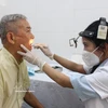 Un anciano recibe un chequeo general de oído, nariz y garganta. (Fuente: VNA)