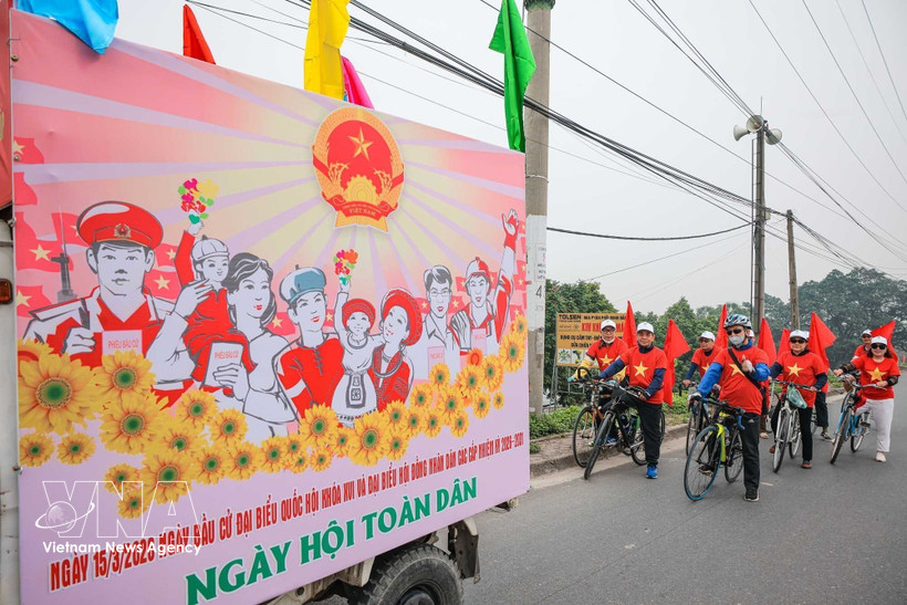 Un equipo de propaganda móvil de la comuna de O Dien, en Hanoi, con uniformes y banderas rojas animando el día de las elecciones. Foto: VNA