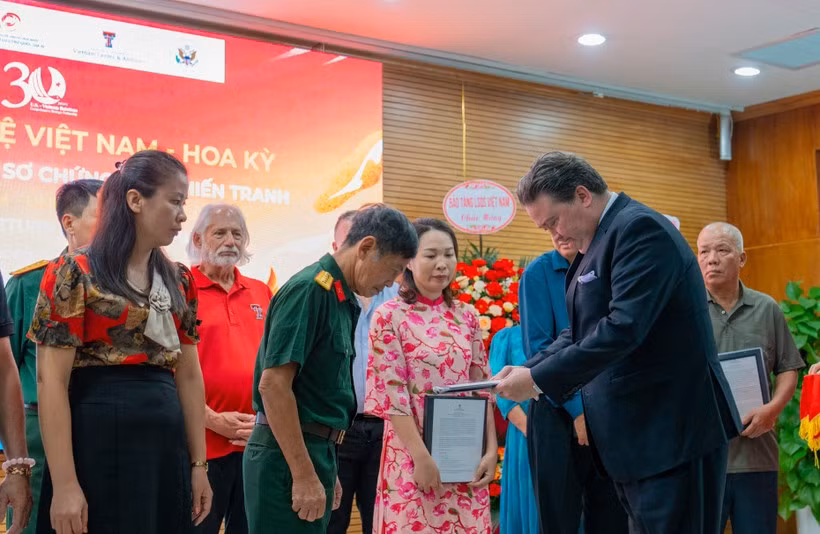 El exembajador de Estados Unidos en Vietnam, Marc E. Knapper, entrega los “Expedientes de evidencias de guerra” en 2025. (Foto: Vietnam+)