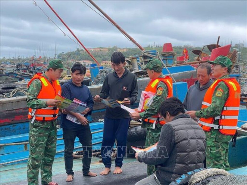 Las tropas de guardia fronteriza coordinan con la guardia costera para realizar propaganda sobre la lucha contra la pesca ilegal, no declarada y no reglamentada en el muelle de Bach Long Vy. (Foto: VNA)