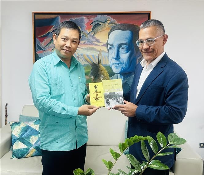 El embajador de Vietnam en Venezuela, Vu Trung My, entrega al ministro venezolano de Cultura, Ernesto Villegas, de obras representativas del Presidente Ho Chi Minh. (Foto: VNA)