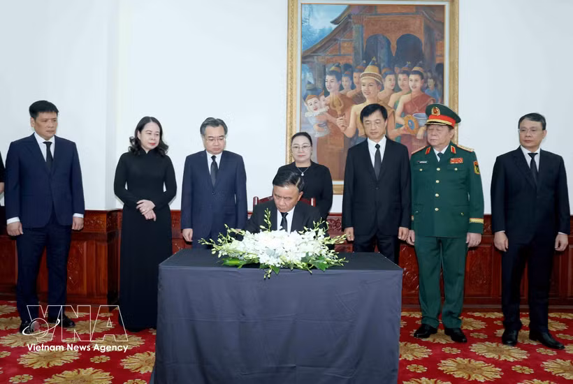 Tran Cam Tu, miembro del Buró Político e integrante permanente del Secretariado del Comité Central del Partido Comunista de Vietnam, escribe en el libro de condolencias por el fallecimiento de Xaysomphone Phomvihane, miembro del Buró Político y presidente de la Asamblea Nacional de Laos. (Foto: VNA)