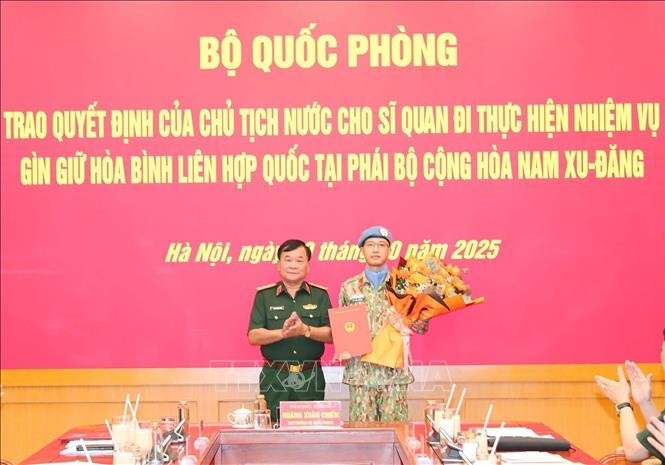 El miembro del Comité Central del Partido Comunista de Vietnam y viceministro de Defensa, teniente general Hoang Xuan Chien, entrega la decisión del Presidente de la República al oficial designado a una misión de mantenimiento de la paz de la Organización de las Naciones Unidas. (Foto: VNA)
