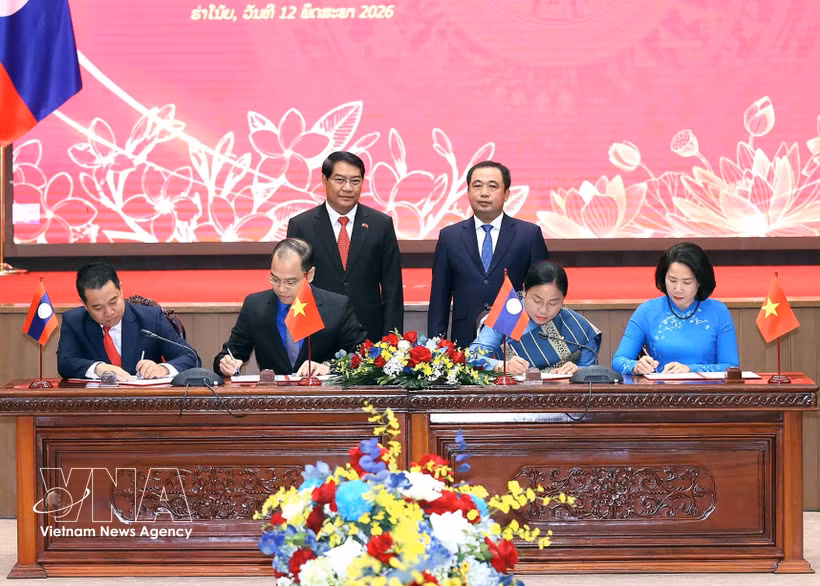 El secretario del Comité del Partido Comunista de Vietnam en Hanoi, Tran Duc Thang, y el jefe del Comité del Partido Popular Revolucionario de Laos en Vientiane, Athsaphangthong Siphandone, presencian la ceremonia de la firma del memorando del entendimiento. (Foto: VNA)