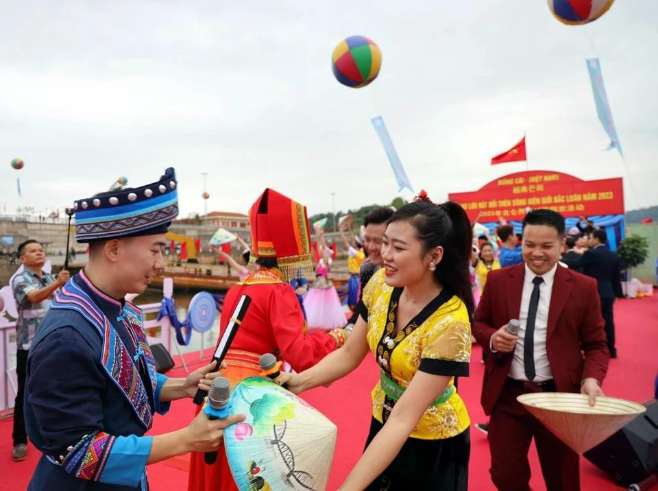 Jóvenes vietnamitas y chinos intercambiaron recuerdos de sombreros cónicos vietnamitas y abanicos chinos. (Foto: VNA). hat-doi-10-9193.jpg