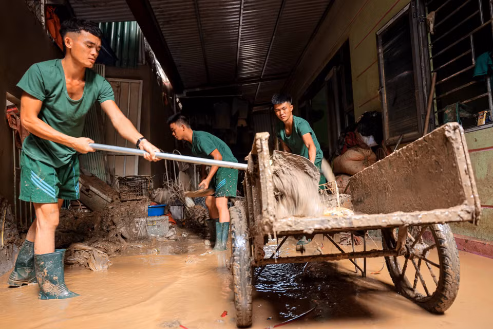 Los soldados de la División 316 ayudan a la gente de la comuna de Phuc Khanh, distrito de Bao Yen, a limpiar sus casas después de la inundación. (Foto: VNA)