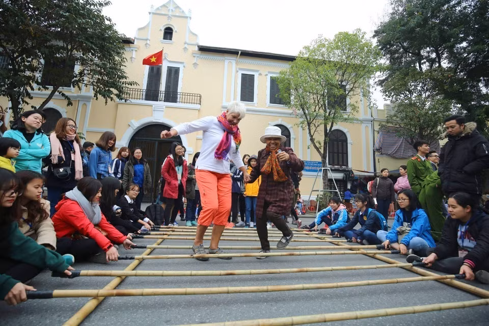 Los visitantes internacionales participan en actividades culturales en la calle peatonal del lago Hoan Kiem (Hanoi). Foto: VNA