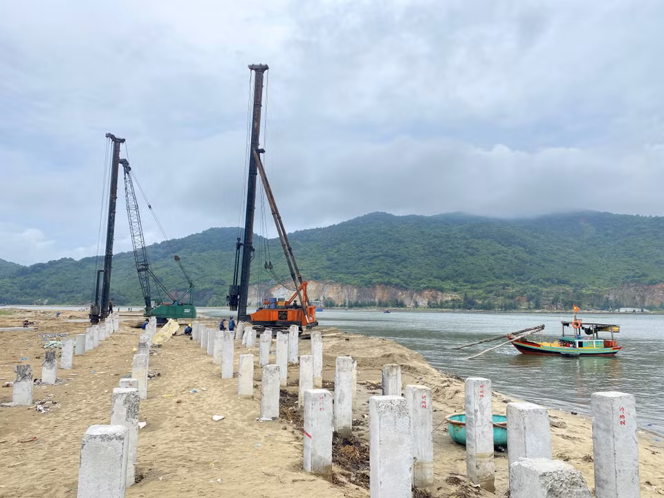Los contratistas colocan columnas de hormigón en el proyecto para mejorar y dragar el puerto pesquero de Thach Kim (distrito de Loc Ha).