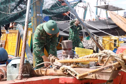 Guardias fronterizos ayudan a los pescadores a evitar el tifón Mayak. Foto: VNA.