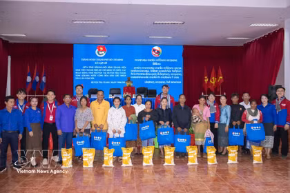 La delegación entrega regalos a familias desfavorecidas en la provincia laosiana de Xekong. Foto: VNA