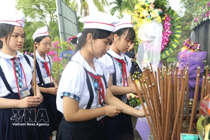 Estudiantes ofrecen incienso en memoria de los fallecidos. Foto: Dinh Huong – VNA