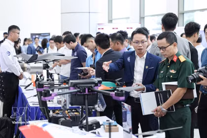 Los delegados visitan los stands de la exposición durante la ceremonia de anuncio de las 3 Redes Estratégicas de Innovación de la Industria Tecnológica el 25 de agosto de 2025. (Foto: VNA)