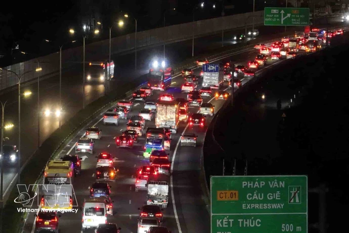 Vehículos circulando lentamente al final de la autopista Phap Van - Cau Gie en dirección al centro de Hanoi la noche del 21 de febrero. Foto: VNA