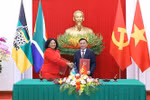 El miembro del Buró Político y permanente del Secretariado del Comité Central del PCV, Tran Cam Tu, y la vicesecretaria general del ANC de Sudáfrica, Nomvula Mokonyane, intercambian un documento de cooperación entre los dos Partidos (Foto: VNA)