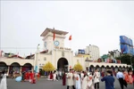 Turistas posan para fotos frente al mercado Ben Thanh, en Ciudad Ho Chi Minh. (Foto: VNA)
