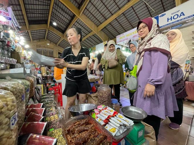 Turistas musulmanes visitan y compran especialidades vietnamitas en el mercado Ben Thanh, en Ciudad Ho Chi Minh. (Foto: https://www.sggp.org.vn/)