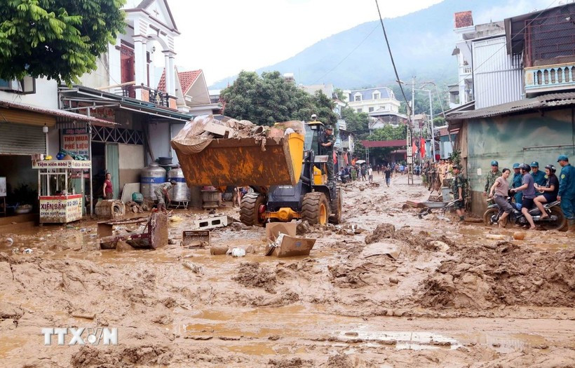 Se movilizaron excavadoras para nivelar y recoger el lodo, las ramas de árboles y la basura arrastrada por la reciente inundación en la comuna de Song Ma, provincia de Son La. (Foto: VNA)