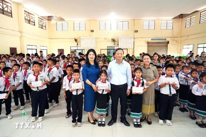 El embajador de Vietnam en Laos, Nguyen Minh Tam y su esposa se toman una foto con representantes escolares y alumnos de la Escuela Bilingüe Laos-Vietnamita Nguyen Du. (Foto: VNA)
