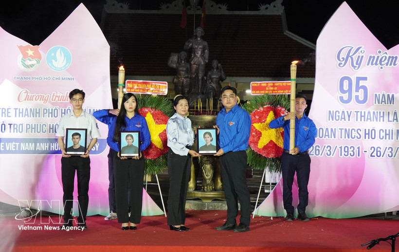Ngo Minh Hai, secretario de la Unión de Jóvenes de Ciudad Ho Chi Minh y presidente de la Unión de Jóvenes de Vietnam en Ciudad Ho Chi Minh, entrega retratos a la familia de la Heroica Madre Vietnamita Nguyen Thi Dau y sus dos hijos, los mártires Tran Thi Sau y Tran Van Chan. (Foto: VNA)