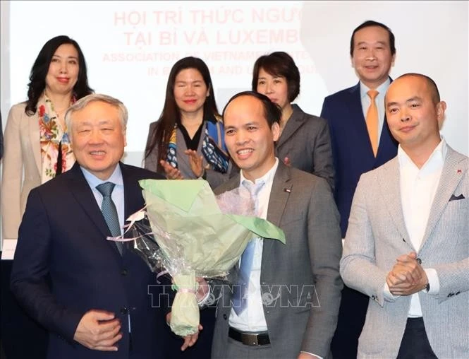 El viceprimer ministro permanente vietnamita, Nguyen Hoa Binh, entrega flores al presidente de ViLaB, Phung Quoc Tri. (Fuente: VNA)