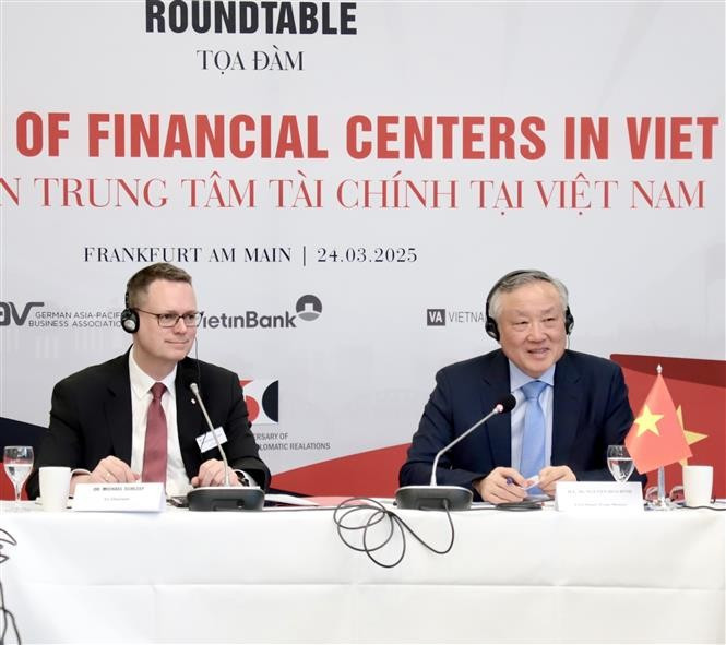 El viceprimer ministro permanente vietnamita Nguyen Hoa Binh (derecha) presidió el coloquio sobre el desarrollo de un centro financiero internacional en Vietnam. (Fuente: VNA)