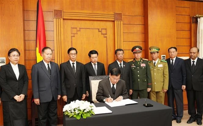 El secretario general del Partido Popular Revolucionario de Laos y presidente del país, Thongloun Sisoulith, escribe en el libro de condolencias. (Fuente: VNA)
