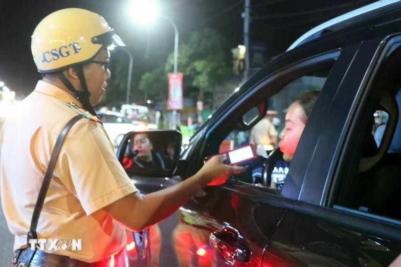 Oficiales del Equipo de Policía de Tránsito de la Policía de la ciudad de Long Xuyen controlan aleatoriamente la concentración de alcohol de los participantes del tráfico. (Foto: VNA)