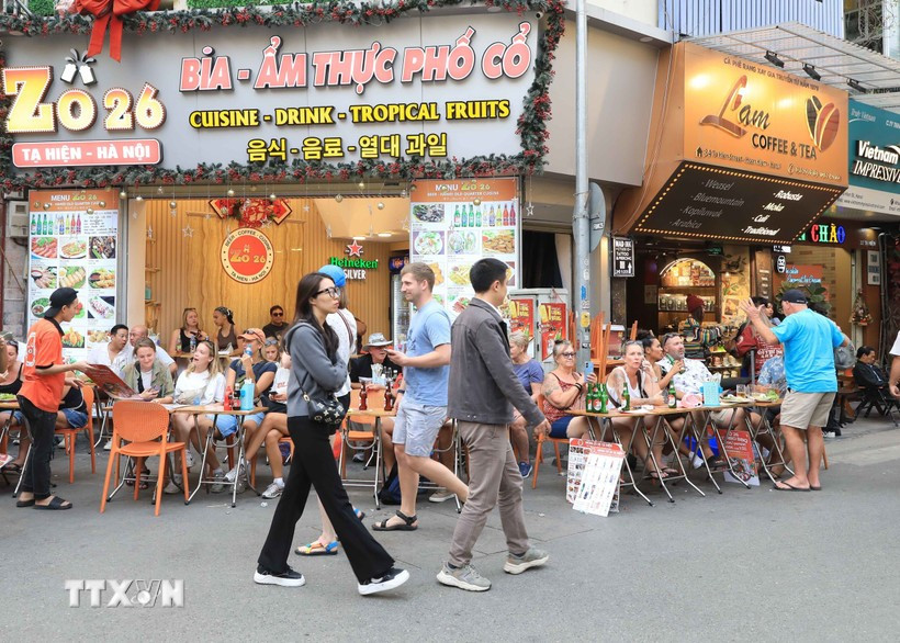 Turistas extranjeros disfrutan de la gastronomía en la calle Ta Hien, Hanoi. (Foto: VNA)