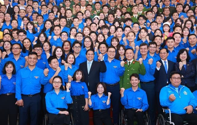 El primer ministro Pham Minh Chinh y los jóvenes. (Fuente: VNA)