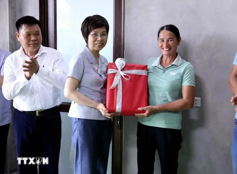 La directora general de la VNA, Vu Viet Trang, entrega obsequio a una familia que recibió apoyo de la agencia para construir una nueva casa. (Foto: VNA)