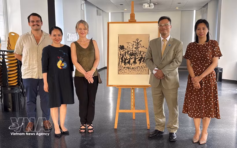 Delegados vietnamitas y franceses posan para una foto conmemorativa junto a la pintura original "¡Viva la paz!" de artista Pablo Picasso. (Fuente: VNA)