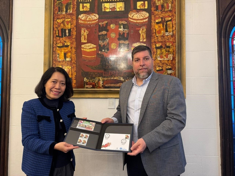 El diputado Víctor Aldaya entrega a la embajadora de Vietnam en Aregentina, Ngo Minh Nguyet, un juego de sellos emitidos por Correos del Uruguay en diciembre de 2013, en conmemoración del 20.º aniversario de las relaciones diplomáticas entre Vietnam y Uruguay, con el retrato del General Vo Nguyen Giap. (Fuente: VNA)