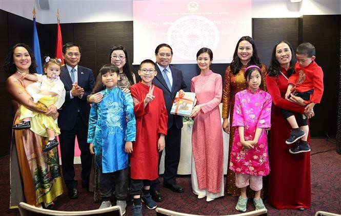El primer ministro Pham Minh Chinh y su esposa otorgan libros en idioma vietnamita a la comunidad de residentes vietnamitas en Estonia. (Foto: VNA)