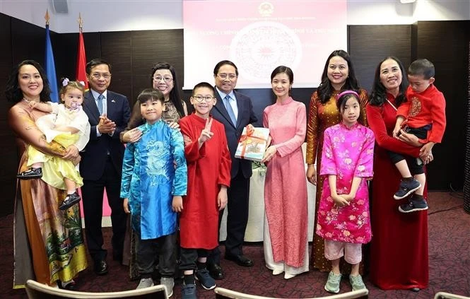 El primer ministro Pham Minh Chinh y su esposa otorgan libros en idioma vietnamita a la comunidad de residentes vietnamitas en Estonia. (Foto: VNA)