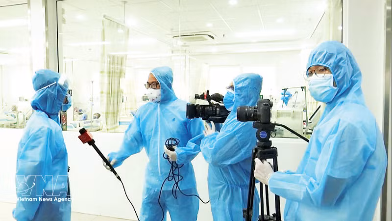 Periodistas trabajando en Da Nang durante el período complejo de la pandemia de la Covid-19. (Foto: VNA)