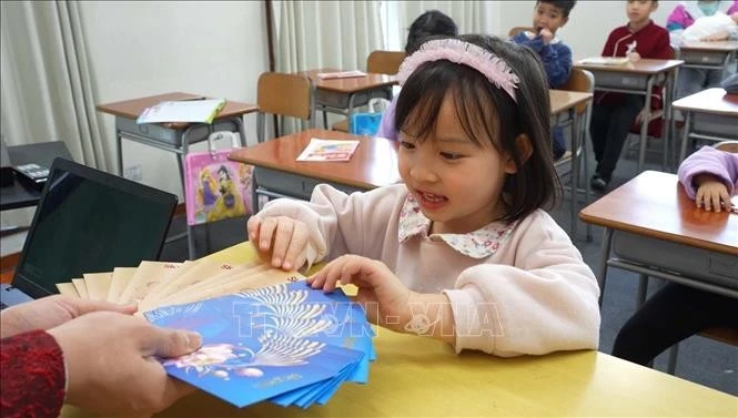 Mai Chi, de 5 años de edad, alumna de la Academia de Lengua y Cultura Dai Viet, se siente emocionada de recibir dinero de la suerte al comienzo del nuevo año según la tradicional costumbre del Tet ( Nuevo Año Lunar). (Fuente: VNA)