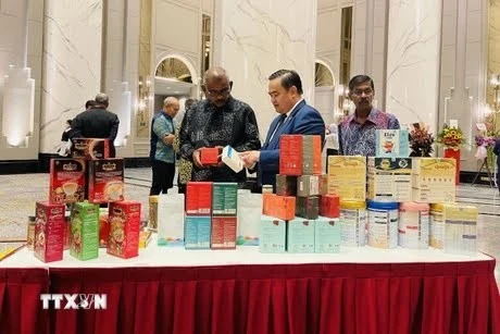 El consejero comercial vietnamita en Malasia, Le Phu Cuong (en el centro), presenta productos tradicionales vietnamitas a los invitados. (Fuente: VNA)