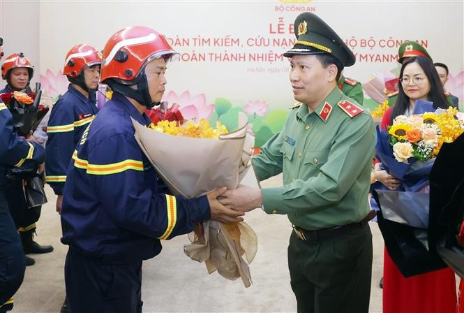El teniente general Le Van Tuyen, viceministro de Seguridad Pública, entregó flores para felicitar a los oficiales y soldados del equipo de búsqueda y rescate de la cartera por completar su misión y regresar de Myanmar. (Fuente: VNA)
