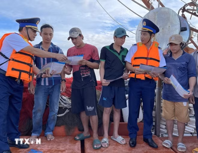 Las fuerzas encargadas de hacer cumplir la ley marítima difunden información sobre la pesca IUU entre los pescadores. (Foto: VNA)