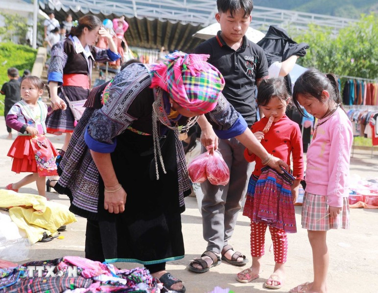 3. El mercado no es solo para adultos, sino también una alegría para los niños, quienes disfrutan ir allí y que sus madres les compren ropa nueva. (Foto: VNA)